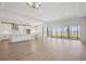 Bright, open-concept living space with modern flooring, recessed lighting, and sliding doors to the backyard at 12977 Long Valley Cir, Spring Hill, FL 34609