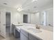 Bright bathroom with dual vanity, grey cabinets, quartz countertop, and large mirror at 3437 Yellow Leaf Cir, Spring Hill, FL 34609