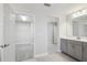 Bathroom with dual vanity, gray cabinets, and entrances to the water closet and walk-in closet at 3437 Yellow Leaf Cir, Spring Hill, FL 34609