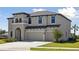 Attractive two-story home with a three-car garage and green lawn at 3437 Yellow Leaf Cir, Spring Hill, FL 34609