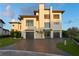 Modern home with two-car garage and brick driveway at 490 Laguna Dr, Tierra Verde, FL 33715