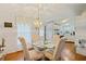 Bright dining area with glass table and striped chairs, kitchen view at 34045 Brown Bayou, Wesley Chapel, FL 33543