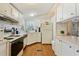 Kitchen with white cabinets, wood flooring, and modern appliances at 34045 Brown Bayou, Wesley Chapel, FL 33543