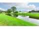 Peaceful waterfront view with lush green grass and reflections of homes in the canal at 34045 Brown Bayou, Wesley Chapel, FL 33543