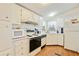 White kitchen with stainless steel appliances and wood flooring at 34045 Brown Bayou, Wesley Chapel, FL 33543