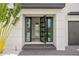 Modern home entry with glass double doors and stone flooring at 490 Laguna Dr, Tierra Verde, FL 33715