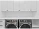 Bright laundry room with modern washer and dryer, and white cabinets at 490 Laguna Dr, Tierra Verde, FL 33715