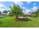 Landscaped backyard featuring a well-maintained lawn, mature trees, and a screened lanai at 1105 Deer Run Pl, Valrico, FL 33594