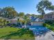 Well-maintained single-story home featuring a lush lawn, mature trees, and a two-car garage, all under a clear blue sky at 1105 Deer Run Pl, Valrico, FL 33594