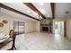 Open-concept living room with exposed wood beam ceiling, tiled floor, and brick fireplace at 1105 Deer Run Pl, Valrico, FL 33594