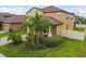 Exterior view of home featuring a well-manicured lawn and tropical landscaping at 11464 Chilly Water Ct, Riverview, FL 33569