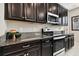 Kitchen counter featuring dark cabinetry, granite countertops, stainless steel appliances, and modern lighting at 11464 Chilly Water Ct, Riverview, FL 33569