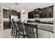 Kitchen island with granite countertops, dark cabinetry, bar stool seating, and stainless steel appliances at 11464 Chilly Water Ct, Riverview, FL 33569