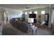 Comfortable living room area with a large television, windows, and modern decor at 6342 Kenava Loop, Palmetto, FL 34221