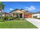 One-story house with orange garage door and landscaped yard at 6342 Kenava Loop, Palmetto, FL 34221