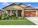 One-story house with orange garage door and landscaped yard at 6342 Kenava Loop, Palmetto, FL 34221