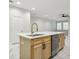 Kitchen island with light wood cabinets, quartz countertop, and stainless steel dishwasher at 2138 -1 W Beach St, Tampa, FL 33607
