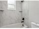 Clean bathroom with a shower/tub combo and marble-look tile at 2138 -1 W Beach St, Tampa, FL 33607