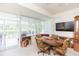 Sunroom features a dining table, large TV and access to the outdoors at 1908 Sterling Glen Ct, Sun City Center, FL 33573