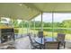 Enjoy this screened patio with a grill, table and chairs, and pond view at 1908 Sterling Glen Ct, Sun City Center, FL 33573