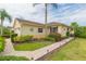 Exterior view of a yellow house with a landscaped yard at 1908 Sterling Glen Ct, Sun City Center, FL 33573