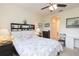 Bright bedroom with a queen bed, ceiling fan, and built-in shelving at 1908 Sterling Glen Ct, Sun City Center, FL 33573