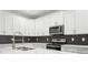 Modern kitchen features white cabinets, stainless steel appliances, and a geometric backsplash at 2138 - 2 W Beach St, Tampa, FL 33607