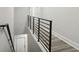 Upstairs hallway with a modern metal railing and wood-look flooring at 2138 - 2 W Beach St, Tampa, FL 33607
