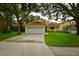 Two-story yellow house with a white garage door at 7519 Harbor View Way, Seminole, FL 33776