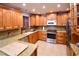 Modern kitchen with wood cabinets, granite counters, and stainless steel appliances at 7519 Harbor View Way, Seminole, FL 33776