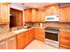 Modern kitchen with wood cabinets, granite counters, and stainless steel appliances at 7519 Harbor View Way, Seminole, FL 33776