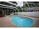 Refreshing kidney-shaped pool with screened enclosure and hot tub at 7519 Harbor View Way, Seminole, FL 33776