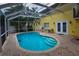 Relaxing screened-in pool area featuring a pool with brick paver decking at 7519 Harbor View Way, Seminole, FL 33776