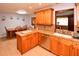 Modern kitchen with stainless steel dishwasher and wood cabinetry at 7519 Harbor View Way, Seminole, FL 33776