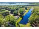 Aerial view of waterfront homes with mature trees and adjacent to a lake at 8945 Overlook Dr, Wesley Chapel, FL 33545