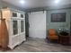 Living room with barn door, white display cabinet, wood floors and sage colored walls at 8945 Overlook Dr, Wesley Chapel, FL 33545