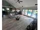 Bright open living room with wood floors, a stone fireplace, and sliding glass doors leading to the pool at 8945 Overlook Dr, Wesley Chapel, FL 33545