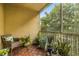 Relaxing screened balcony with tiled floor, potted plants, and wicker chair at 17104 Carrington Park Dr # 520, Tampa, FL 33647