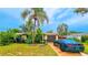 Single story home with palm trees, dark garage door, and a car parked on the driveway at 3518 Pinehurst Dr, Holiday, FL 34691