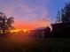 Rustic red outbuilding with a sunset backdrop at 8945 Overlook Dr, Wesley Chapel, FL 33545