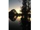 Tranquil lakefront property at sunset; water reflections at 8945 Overlook Dr, Wesley Chapel, FL 33545