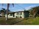 A cozy one-story home featuring well-kept front yard and painted in a pleasing, muted green tone at 5805 Oxford Dr, Tampa, FL 33615