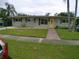 Single-story home featuring a well-manicured lawn and a cozy walkway, all under a pleasant sky at 5805 Oxford Dr, Tampa, FL 33615