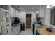Functional kitchen with white cabinets and modern appliances, next to a view of the dining area at 5805 Oxford Dr, Tampa, FL 33615