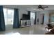 Bright living room with tile floors, large windows with curtains, and a modern entertainment center at 5805 Oxford Dr, Tampa, FL 33615