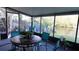 Enclosed patio featuring a round table and chairs overlooking a serene backyard and waterway at 5805 Oxford Dr, Tampa, FL 33615