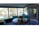Enclosed porch features waterfront views with table and chairs for outdoor enjoyment at 5805 Oxford Dr, Tampa, FL 33615