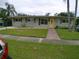 Ranch-style home with a yellow door and brick walkway at 5805 Oxford Dr, Tampa, FL 33615