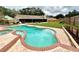 Relaxing freeform pool with brick pavers and a covered patio at 2321 Rothenfeld Ct, Land O Lakes, FL 34639