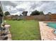 Spacious grassy backyard with wooden fence and a glimpse of the pool at 2321 Rothenfeld Ct, Land O Lakes, FL 34639
